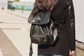 Stylish dressed brunette model posing witn a black leather backpack Royalty Free Stock Photo