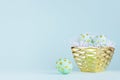 Stylish easter background with blue easter eggs with gold dots in glossy bowl on blue color. Royalty Free Stock Photo