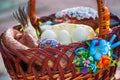 Stylish easter basket with food. horseradish, butter, sausage and painted eggs in wicker basket.