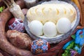 Stylish easter basket with food. horseradish, butter, sausage and painted eggs in wicker basket.