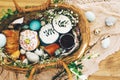 Stylish Easter basket with modern eggs, easter bread cake, ham, beets, sausage, butter and green branches on rustic fabric with Royalty Free Stock Photo