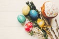 Stylish easter eggs and easter bread cake and flowers on wooden