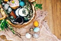 Stylish Easter eggs, easter bread cake, ham, beets, sausage, butter, green branches in wicker basket on rustic fabric with spring Royalty Free Stock Photo