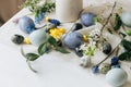 Stylish easter eggs and spring flowers on rustic wooden table. Happy Easter! Natural dye marble and blue eggs, purple hiacynt