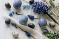 Stylish easter eggs and spring flowers on rustic wooden table. Happy Easter! Natural dye marble and blue eggs, purple hiacynt