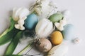 Stylish Easter eggs and tulips on rustic white wooden background. Happy Easter!  Natural dyed colorful eggs, spring flowers, Royalty Free Stock Photo