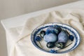 Stylish easter eggs on vintage plate and spring flowers on rustic table. Happy Easter! Natural dye blue eggs, purple hiacynt