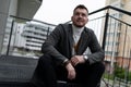 stylish elegant caucasian man sitting on steps smiling looking at camera Royalty Free Stock Photo