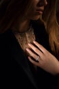 Stylish elegant necklace on the black photo background. Expensive pendant with a diamond on her neck. Fashion blogger