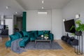 Stylish emerald green sofa in tv room