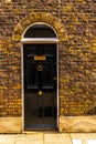 stylish entrance to a residential building, an interesting facade of the old brick arches above the door, a typical old English b