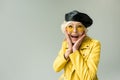 stylish excited senior woman in yellow jacket and leather beret,