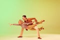 Stylish, expressive, talented young man and woman in vintage clothes dancing against gradient green yellow background