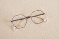 stylish eye glasses in a round metal frame on the sand Royalty Free Stock Photo