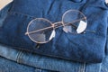 stylish eye glasses on a stack of jeans Royalty Free Stock Photo