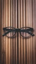 Stylish eyeglasses with black frames set against natural wooden background