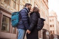 Stylish fashion couple of hipsters with backpacks kissing in winter on a city street. Stunning sensual outdoor portrait Royalty Free Stock Photo