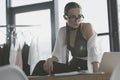 stylish fashion designer sitting on work desk