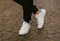 Stylish fashionable white womens leather shoes. Womens legs with sneaker