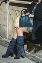 Stylish fashionable woman in dark blue suede boots and dress. Girl in winter boots with leather bag on the street Royalty Free Stock Photo