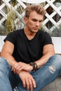 Stylish fashionable young model man in black T-shirt with jeans