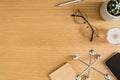 Stylish flat lay business composition on the wooden desk with glasses, notes, pen, copy space and office supplies.