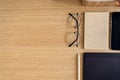 Stylish flat lay business composition on the wooden desk with glasses, notes, pen, copy space and office supplies .