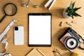 Stylish flat lay business composition on the wooden desk with mock up tablet, cacti, notes, photo camera and office supplies. Royalty Free Stock Photo