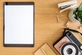 Stylish flat lay business composition on the wooden desk with mock up tablet, cacti, notes, photo camera and office supplies. Royalty Free Stock Photo