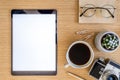 Stylish flat lay business composition on the wooden desk with mock up tablet, cacti, notes, photo camera and office supplies. Royalty Free Stock Photo