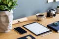 Stylish flat lay business composition on the wooden desk with mock up tablet, cacti, notes, photo camera and office supplies . Royalty Free Stock Photo