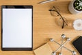 Stylish flat lay business composition on the wooden desk with mock up tablet, cacti, notes, photo camera and office supplies . Royalty Free Stock Photo