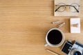 Stylish flat lay business composition on the wooden desk with photo camera, cacti, pen, copy space and office supplies . Royalty Free Stock Photo