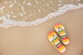 Stylish flip flops on sand  sea, top view with space for text. Beach accessories Royalty Free Stock Photo