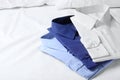 Stylish folded shirts on bed. Dry-cleaning service Royalty Free Stock Photo