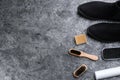 Stylish footwear with shoe care accessories on grey stone table, flat lay Royalty Free Stock Photo