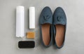 Stylish footwear with shoe care accessories on light grey stone table, flat lay Royalty Free Stock Photo