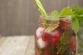 Stylish fresh ice, cold fruit tea background, Mason jar cup with straw, summer fruit tea drink, wooden background. close up with