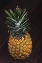 Stylish Fresh Pineapple being seen from a the top on a brown wooden table