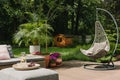 Stylish garden decoration with fancy egg chair and garden furniture Royalty Free Stock Photo