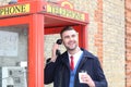 Stylish gentleman calling from vintage payphone Royalty Free Stock Photo