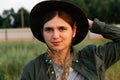 Stylish girl. Defocus young woman in cowboy hat. Girl in a cowboy hat in a field. Nature background. Closeup portrait