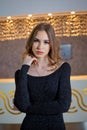 Stylish girl doing a photo shoot in a beauty salon. The blonde girl is photographed in a black dress . Azerbaijan Baku. 03.02.2018
