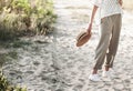 A stylish girl in light beige pants and with a straw hat in her hands Royalty Free Stock Photo