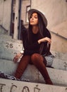 Stylish girl model posing sitting on the steps