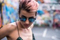 Stylish Girl at painted Basket Box. Street punk girl with pink dyed hair. Woman with piercing in nose, ears tunnels and