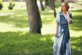 Stylish girl posing in a dress in a sunny spring park. Cheerful, happy portrait of a beautiful girl in the summer Royalty Free Stock Photo