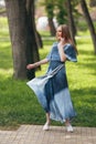 Stylish girl posing in a dress in a sunny spring park. Cheerful, happy portrait of a beautiful girl in the summer Royalty Free Stock Photo