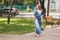 Stylish girl posing in a dress in a sunny spring park. Cheerful, happy portrait of a beautiful girl in the summer Royalty Free Stock Photo