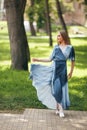 Stylish girl posing in a dress in a sunny spring park. Cheerful, happy portrait of a beautiful girl in the summer Royalty Free Stock Photo